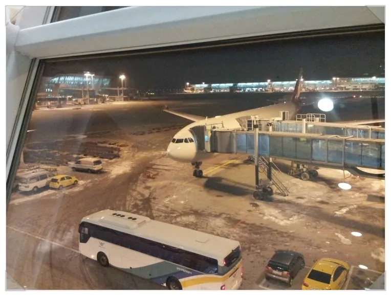 눈 덮인 공항 계류장과 비행기