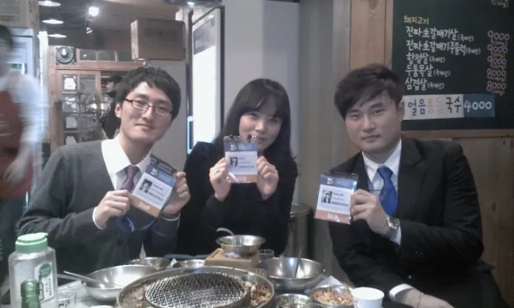 식당에서 명찰을 들고 있는 세 사람